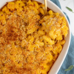 Pinterest pin with logo "The Schmidty Wife", image of a casserole dish filled with baked pumpkin Mac and cheese.