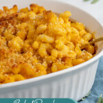 Pinterest pin with text overlay "Baked Pumpkin Mac & Cheese", image of a white casserole dish with a serving spoon scooping out Mac and cheese.