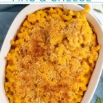 Pinterest pin with text overlay "Baked Pumpkin Mac & Cheese", image of a white casserole dish with a serving spoon scooping out Mac and cheese.