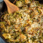 Pinterest Pin with logo overlay "The Schmidty Wife", image of skillet filled with cheesy baked brussel sprouts.