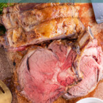 Pinterest Pin with text overlay 'how to make prime rib', image os a cut of prime rib up against a large prime rib roast on a cutting board.
