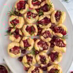 Pinterest pin with logo "The Schmidty Wife", image of platter of cranberry brie bites.