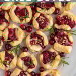 Pinterest pin with text "Cranberry Brie Bites", image of a platter of cranberry brie bites garnished with fresh rosemary.