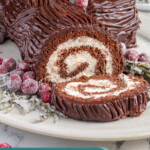 Pinterest pin with text overlay "Yule Log Cake", image of a chocolate roll up cake with whipped filling and a chocolate ganache frosting that looks like tree bark.