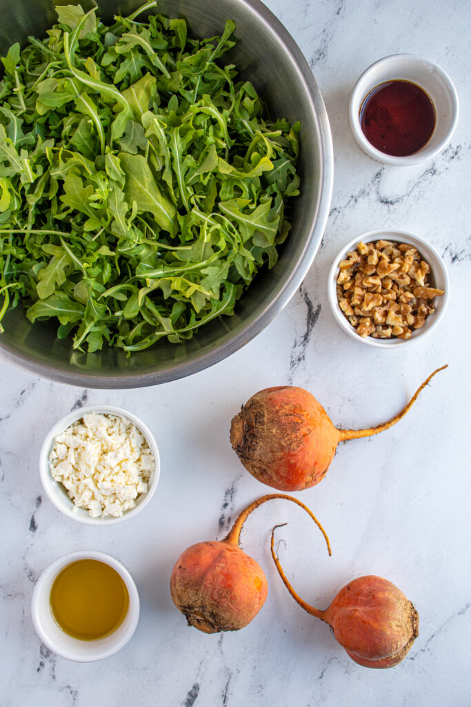 Overhead view of ingredients needed to make golden beet and arugula salad.