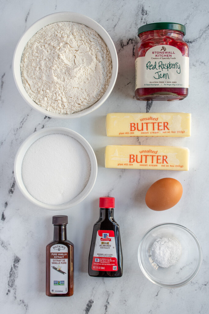 Ingredients needed to make raspberry thumbprint cookies laid out on a tabletop.