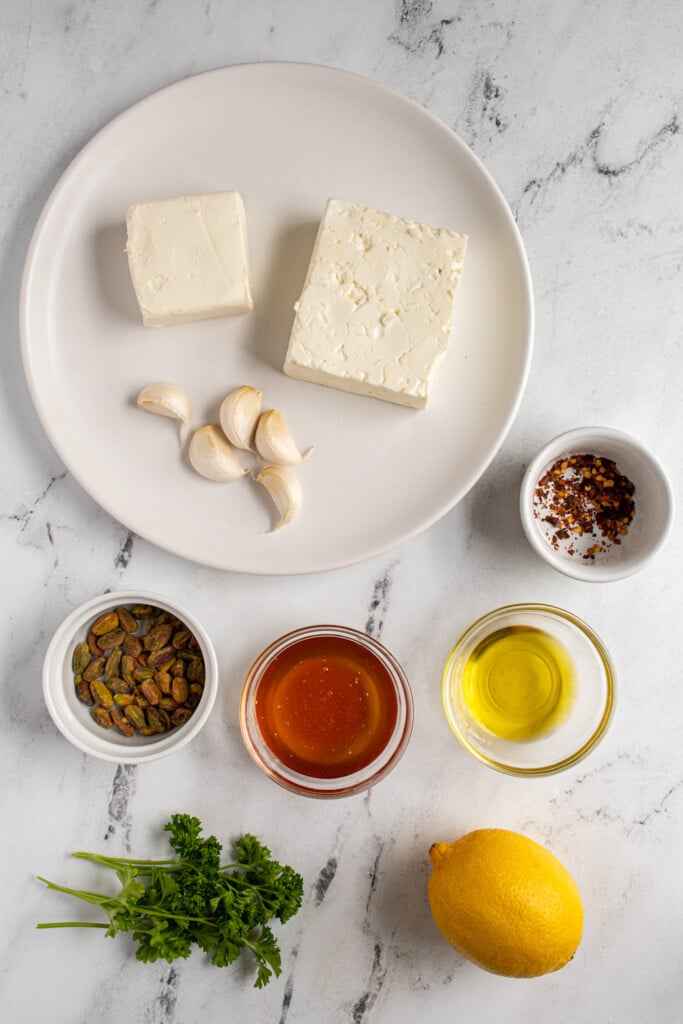 Ingredients needed to make whipped feta with honey laid out on a table top.