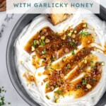 Pinterest pin with text overlay 'Whipped Feta with Garlicky Honey', image of a bowl with whipped feta dip and honey.