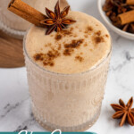 Pinterest pin with test overlay 'Chai Spice Banana Smoothie', image of a glass filled with a light brown banana chai smoothie with garnishes.