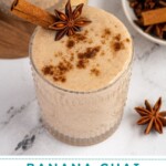 Pinterest pin with test overlay 'Banana Chai Smoothie', image of a glass filled with a light brown banana chai smoothie with garnishes.