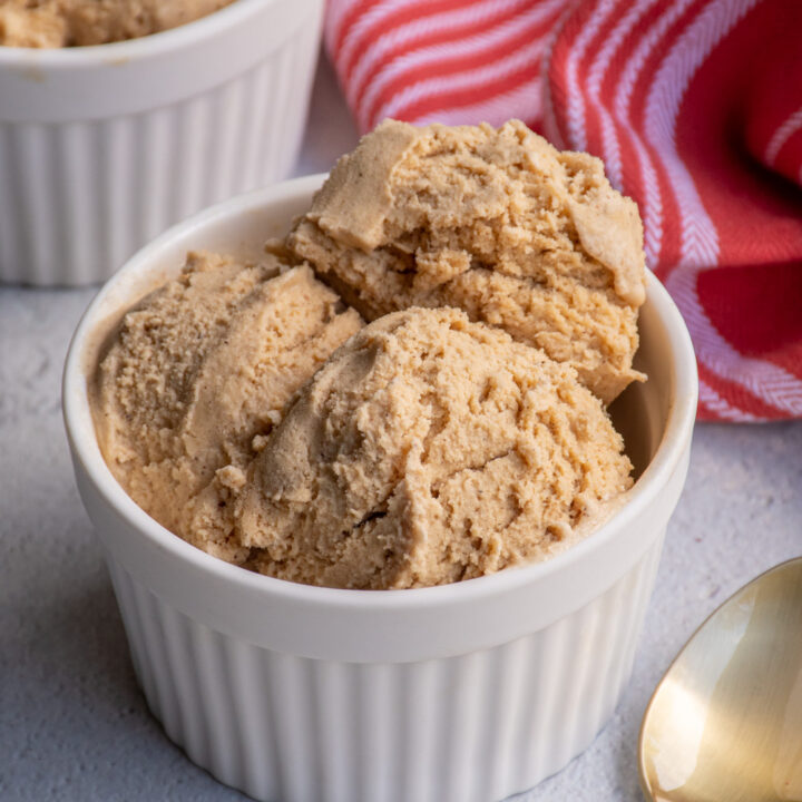 White bowl filled with light brown colored gingerbread ice cream.