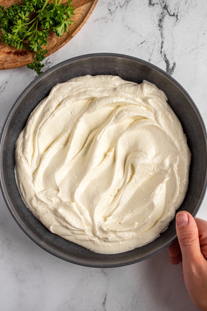 Whipped feta in a gray serving bowl with indentations to hold the honey.