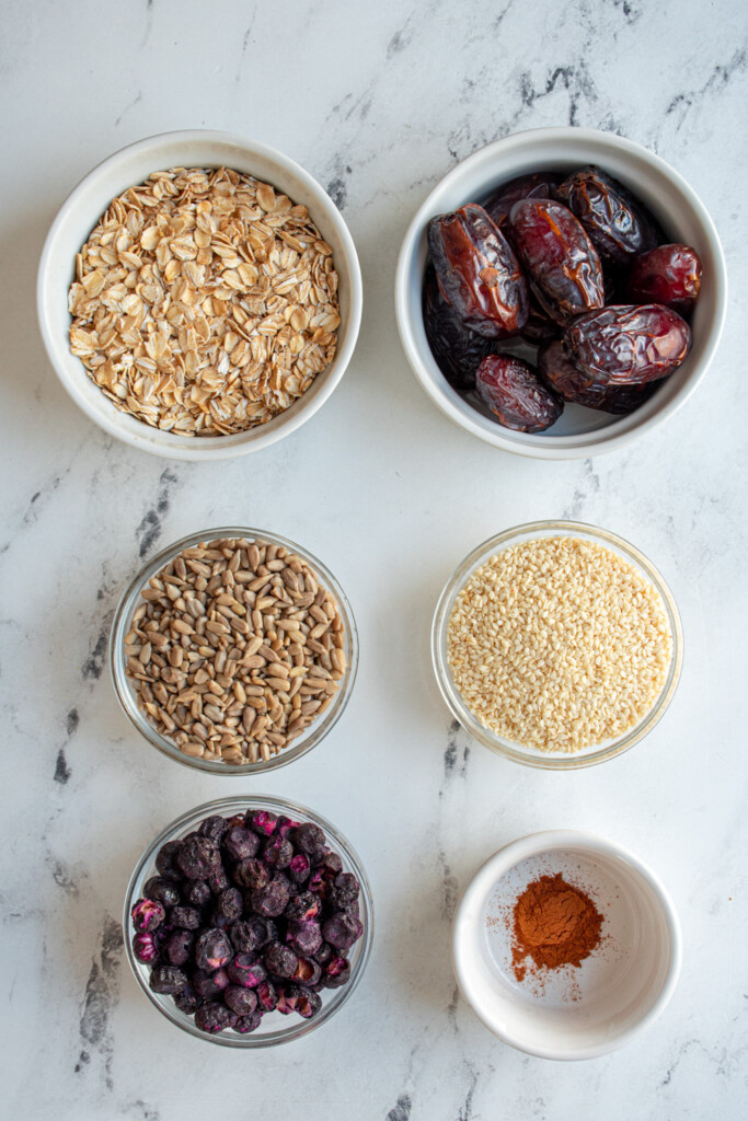 Ingredients needed to make blueberry energy balls laid out on a table top.