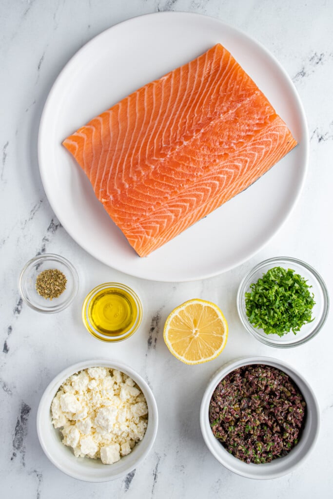 Ingredients needed to make salmon with olive tapenade laid out on a tabletop.