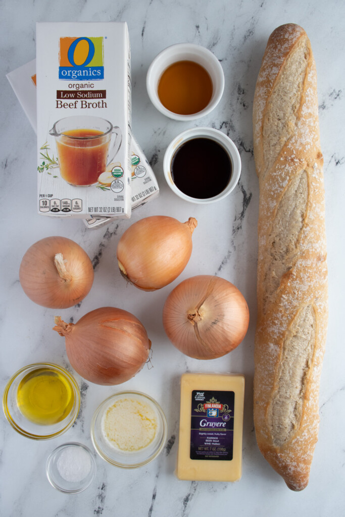 Ingredients to make French onion soup in the slow cooker laid out on a tabletop.