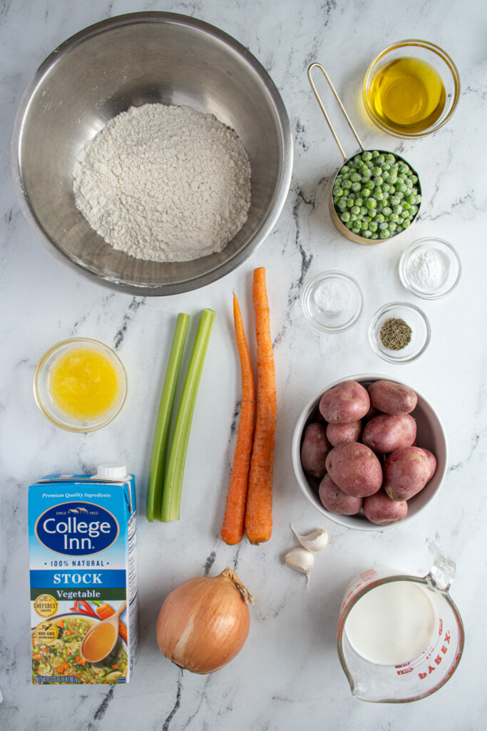 Ingredients needed to make veggie dumpling soup laid out on a tabletop.