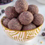 Pinterest Pin with logo overlay "The Schmidty Wife", image of a bowl of purple blueberry energy balls.