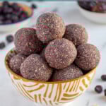 Pinterest Pin with text overlay "Blueberry Energy Balls", image of a bowl of purple blueberry energy balls.