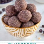 Pinterest Pin with text overlay "Blueberry Energy Balls", image of a bowl of purple blueberry energy balls.