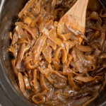 Pinterest pin with logo overlay 'the Schmidty wife', image of a crockpot filled with caramelized onions.