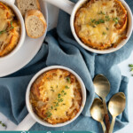 Pinterest pin with text overlay 'slow cooker French onion soup', image of a white bowl filled with French onion soup and topped with baguette and melted cheese.