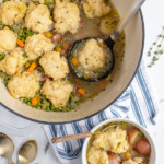 Pinterest pin with logo 'the Schmidty Wife', image of a large pot filled with veggie dumpling soup.