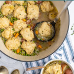 Pinterest pin with text overlay 'Cozy Veggie Dumpling Soup', image of a large pot filled with veggie dumpling soup.