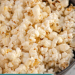 Pinterest pin with text overlay "How to Make Stovetop Popcorn", image of a gray sewing bowl filled with stovetop popcorn.