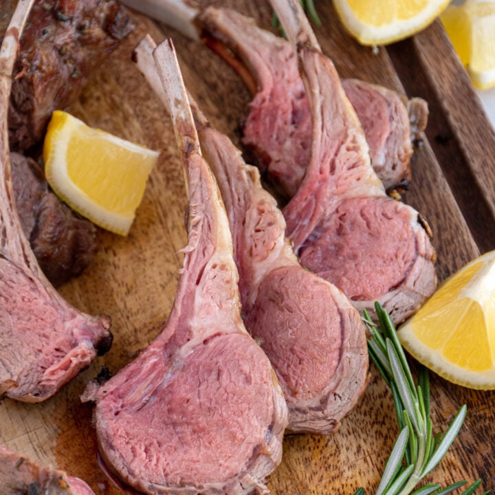 Cut grilled rack of lamb leaning against each other showing of the pink interior lamb meat.