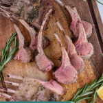 Pinterest pin with text overlay 'Grilled Rack of Lamb', image of rack of lamb cut into pieces and waiting to be served on a wood cutting board.