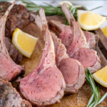 Pinterest pin with text overlay 'Grilled Rack of Lamb', image of rack of lamb cut into pieces and waiting to be served on a wood cutting board.