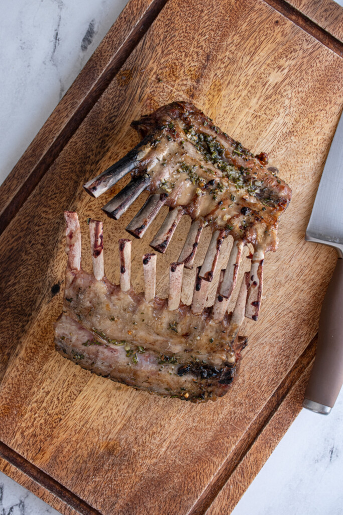 The two racks of lambs standing against each other after resting waiting to be cut apart.