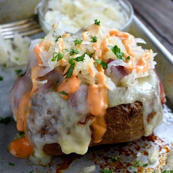 Reuben Stuffed Baked Potato covered with sauerkraut and dripping with 1,000 island dressing