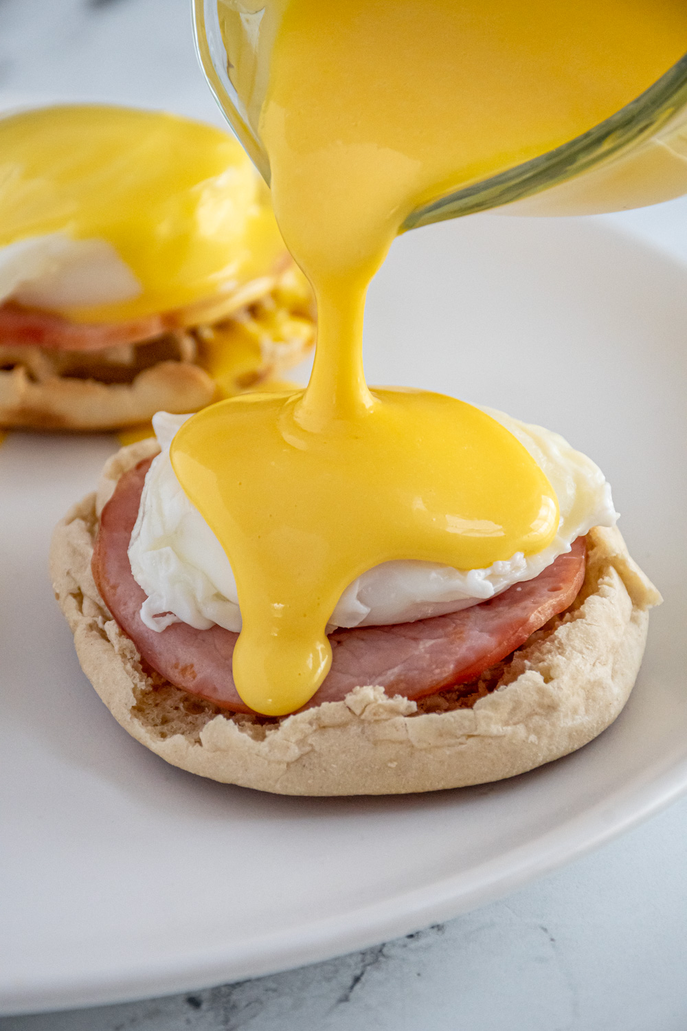 Blender Hollandaise Sauce being poured overtop a poached egg.
