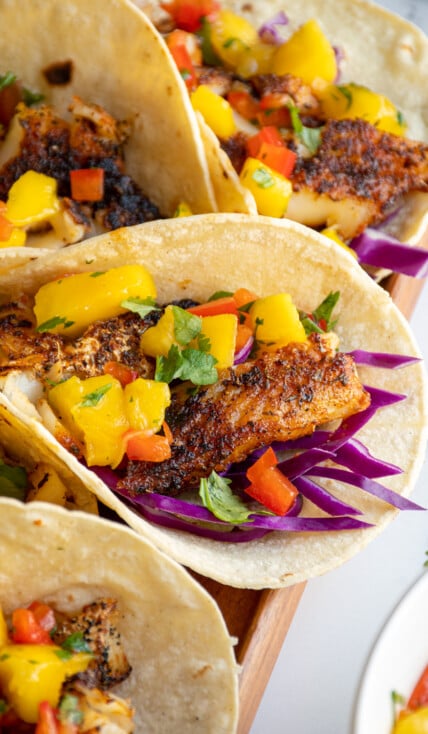 A blackened fish taco with mango salsa with fresh cilantro for a garnish.