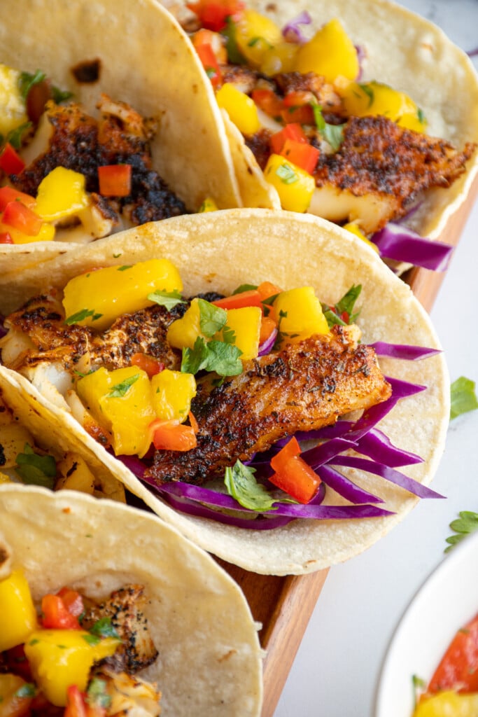 A blackened fish taco with mango salsa with fresh cilantro for a garnish.