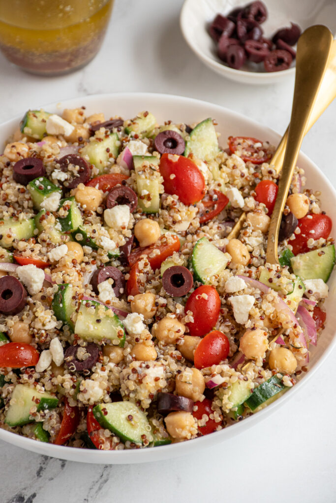 A white bowl filled with greek quinoa chickpea salad.