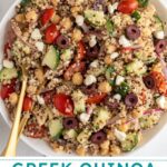Pinterest pin with text overlay "Greek Quinoa Chickpea Salad", image of a white bowl filled with greek quinoa salad with chickpeas.