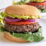 Pinterest pin with logo "The Schmidty Wife", image of a grilled black bean burger in a bun.