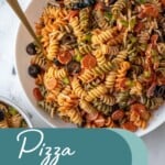 Pinterest pin with text overlay "Pizza Pasta Salad" with image of a bowl filled with colorful pizza pasta salad.