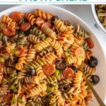 Pinterest pin with text overlay "Pizza Pasta Salad" with image of a bowl filled with colorful pizza pasta salad.