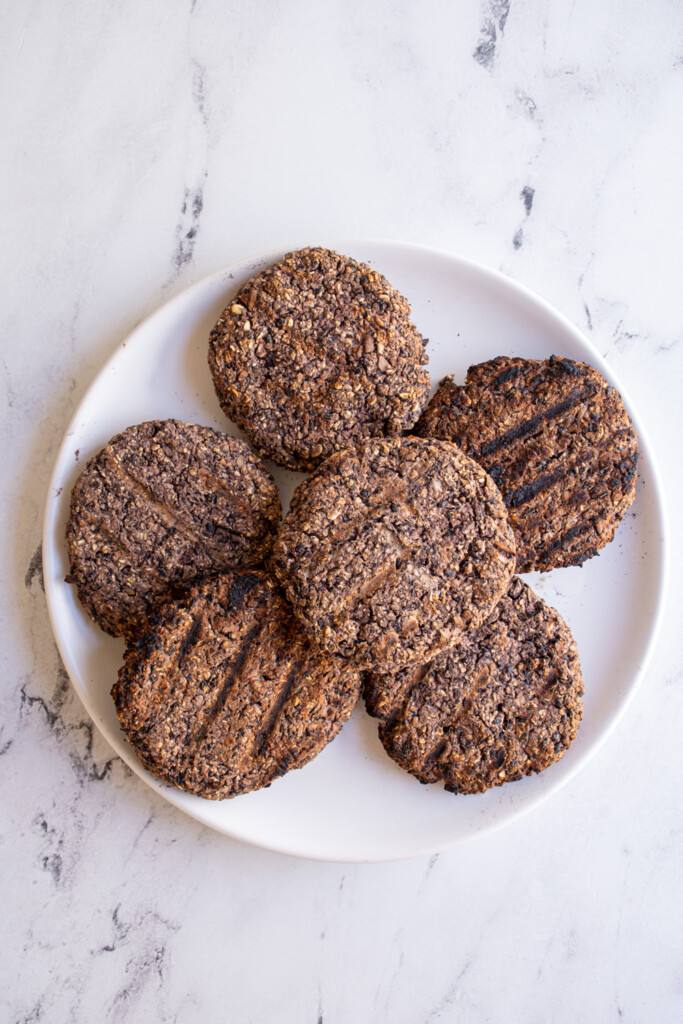 Grilled black bean burgers on a white plate.