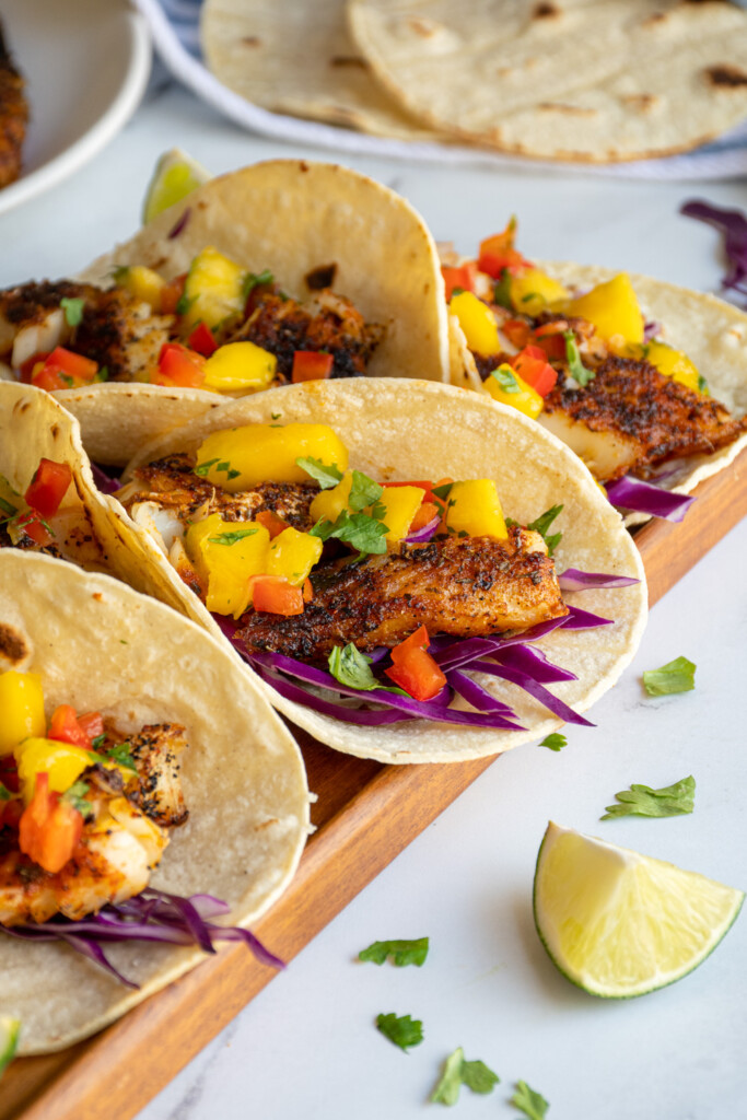 A corn tortilla with red cabbage, blackened fish, and mango salsa.