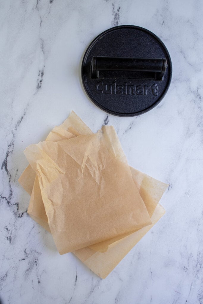 A burger press and brown parchment paper.