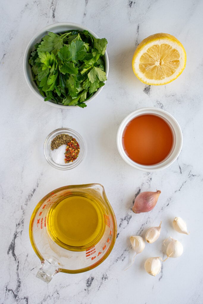 Ingredients to make chimichurri laid out on a table top.