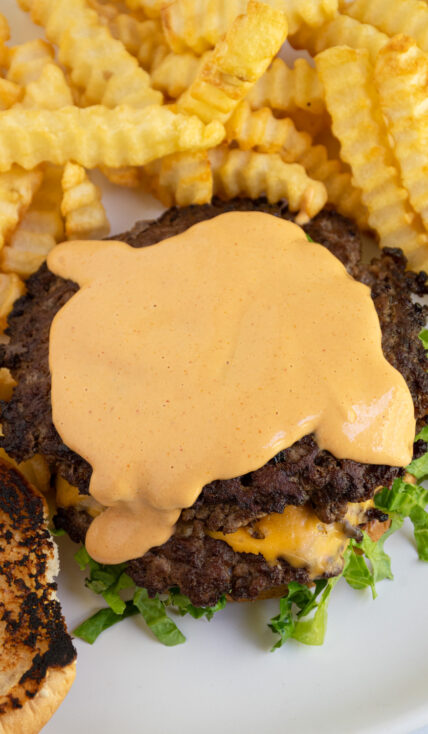 Homemade Big Mac sauce spread across the top of a burger.