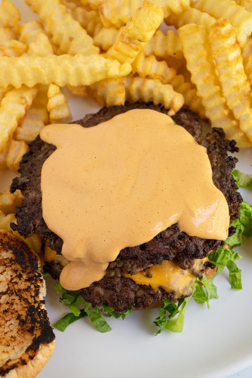 Homemade Big Mac sauce spread across the top of a burger.
