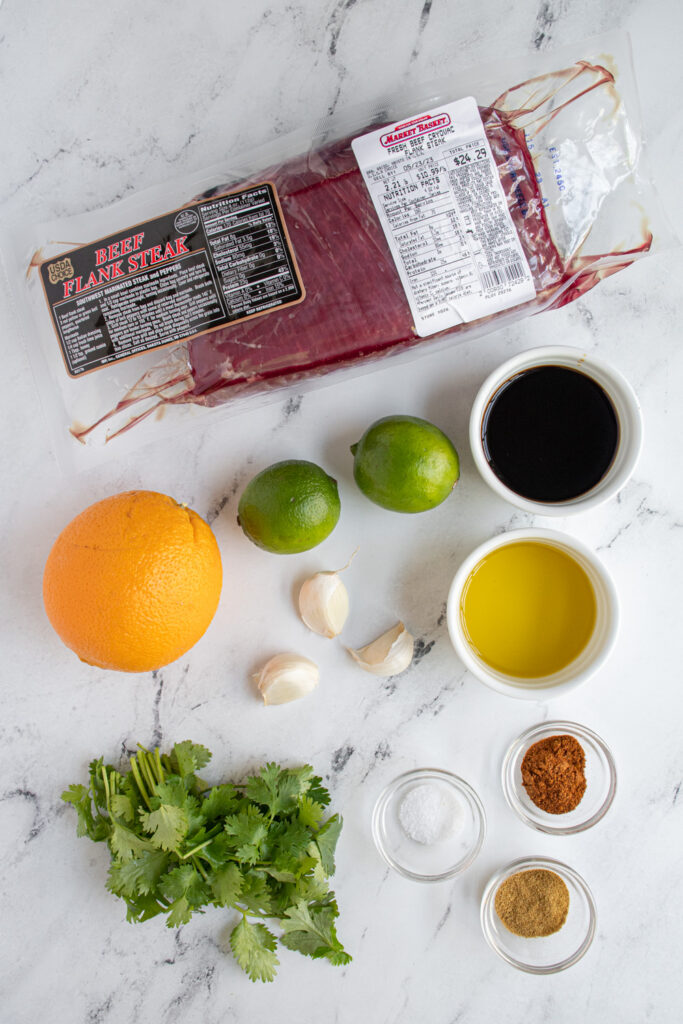 The ingredients needed to make carne asada on a tabletop.