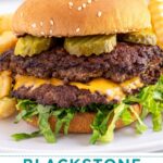 Pinterest pin with text overlay "Blackstone Smash Burgers" with the image of a double smash burger in a bun with lettuce and pickles.