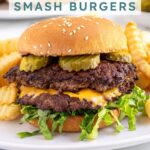 Pinterest pin with text overlay "Blackstone Smash Burgers" with the image of a double smash burger in a bun with lettuce and pickles.